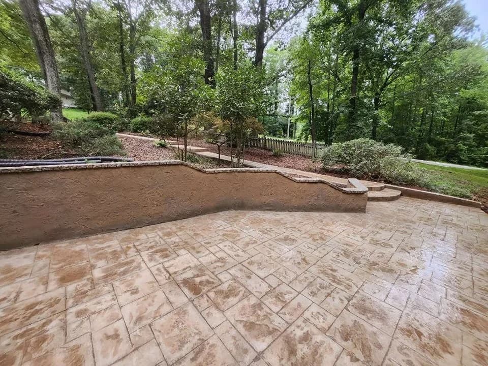 CTech outdoor concrete work bordered by a curved stone retaining wall