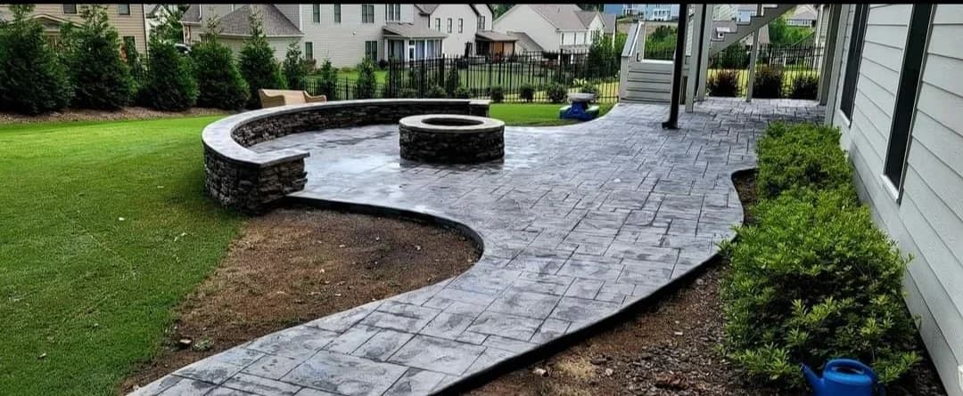 CTech stamped concrete patio with a circular fire pit and curved retaining wall